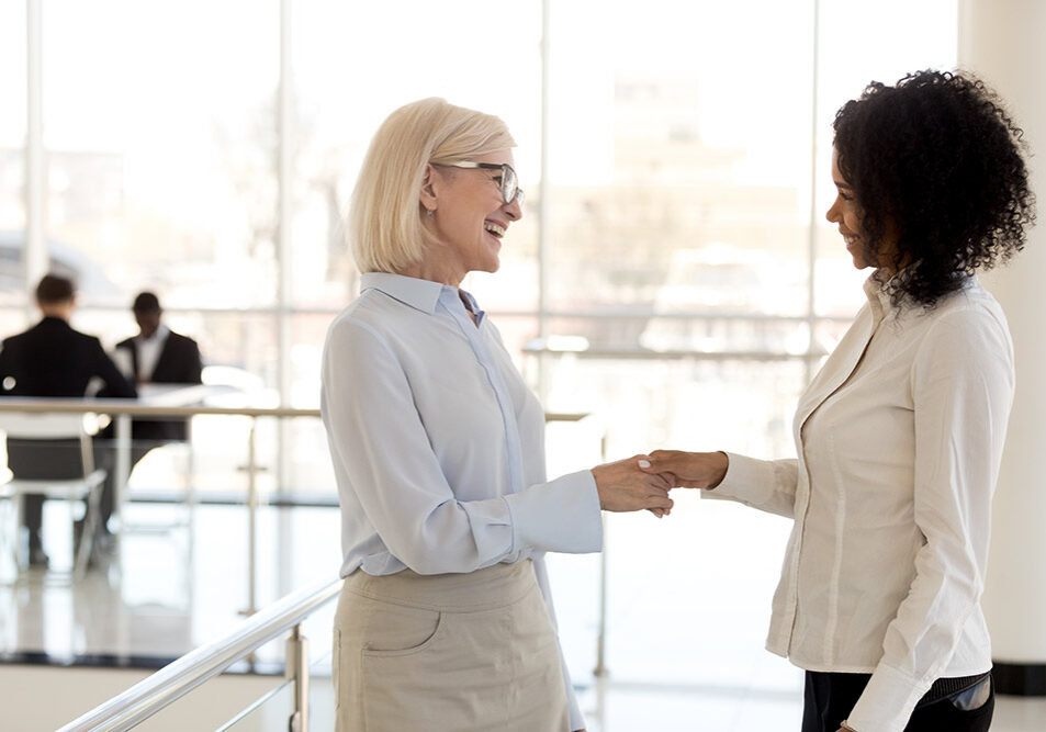Diverse businesswomen shaking hands greeting each other